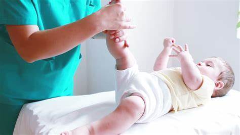 Physiotherapist testing babys range of motion 