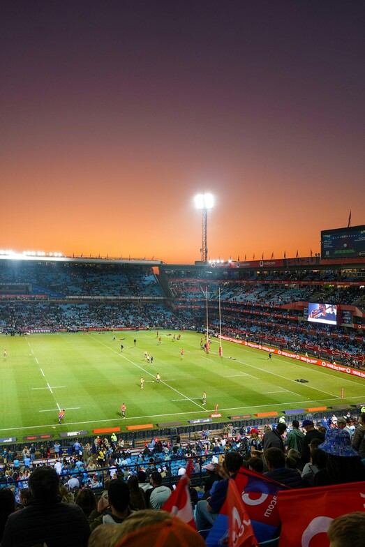 View of soccer field from high up in the stands during a sunset game